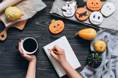 Cadılar Bayramı için gingerbread ile masada oturan kız 