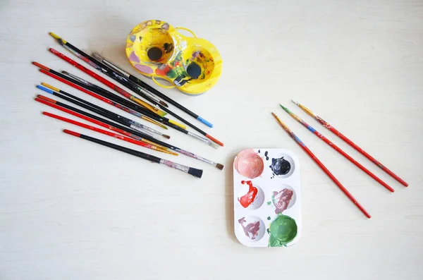 dizi fırçalar, palet, bir bardak su ile