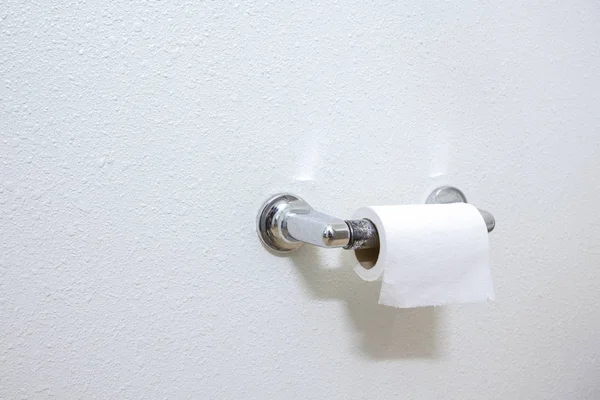 Un rollo de papel higiénico blanco colgado en un papel higiénico de cromo hol — Foto de Stock