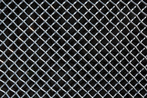 Metal mesh or aluminum grid on black background — Stock Photo, Image