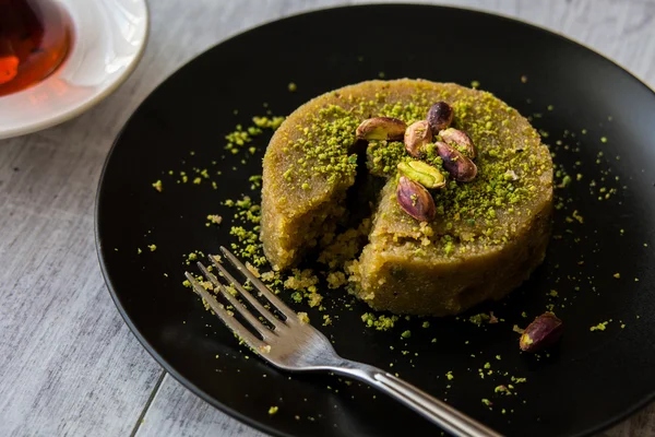 Postre turco irmik helvasi con polvo de pistacho y té . — Foto de Stock