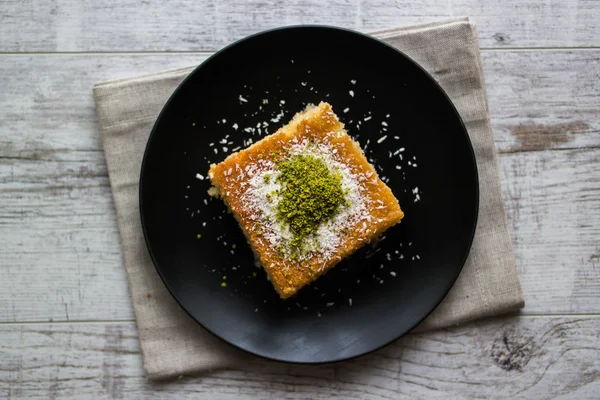 Turkish Dessert Revani with pistachio powder. — Stock Photo, Image