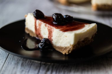 Siyah bir tabak içinde ev yapımı kiraz Cheesecake