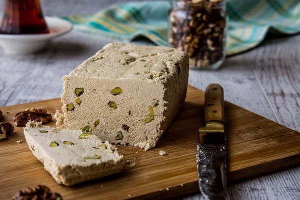 Halva-Scheiben mit Erdnuss-Walnuss und Tee auf einer Holzoberfläche. — Stockfoto