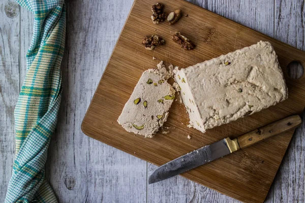 Halva Slice com amendoim e noz em uma superfície de madeira . — Fotografia de Stock