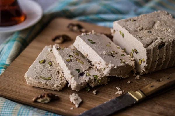 Slices of Halva with Peanut, walnut and tea on a wooden surface. — Stock Photo, Image