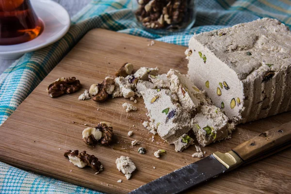 Skiver af Halva med jordnød, valnød og te på en træoverflade . - Stock-foto