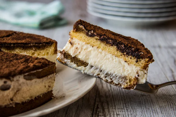 Gâteau Tiramisu fait maison sur une surface en bois blanc . — Photo