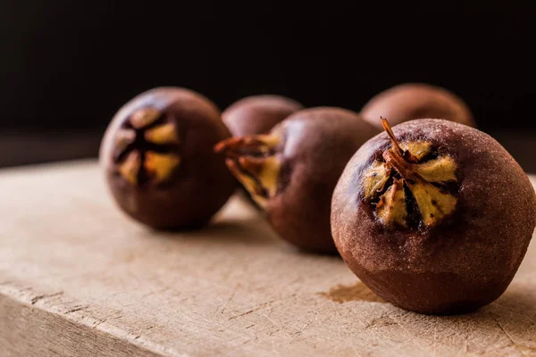 Medlar Frutas em uma superfície de madeira . — Fotografia de Stock