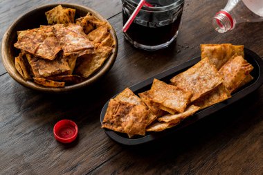 Ev yapımı gevrek cipsi / aperatifler içecek bir ahşap kase.