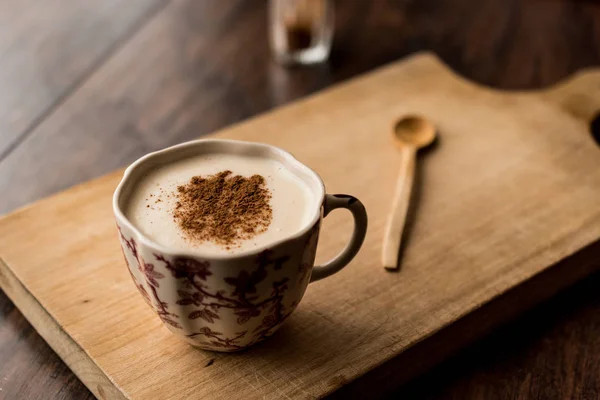 Turkish Salep with cinnamon sticks on a wooden surface. — Stock Photo, Image