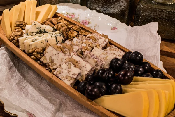 Cheese plate: Emmental, Camembert cheese, blue cheese, cheddar, grape, walnuts — Stock Photo, Image