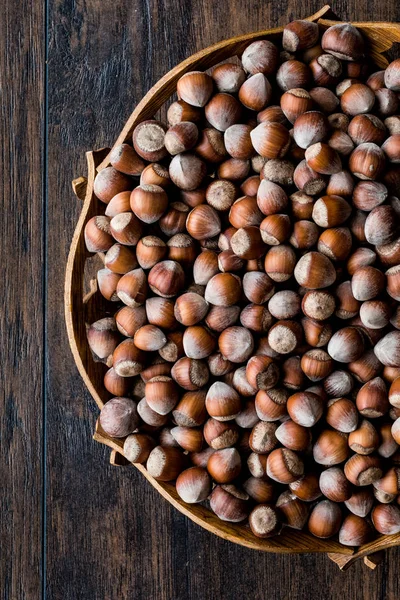Stack of Hazelnuts in wooden bowl. Top view. Copy space. — Stock Photo, Image