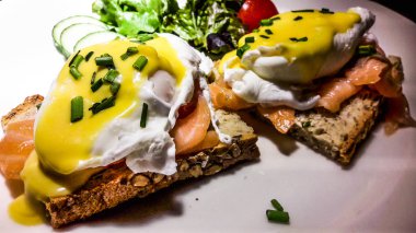 Kızarmış ekmek üzerinde füme somon Yumurta Benedict.
