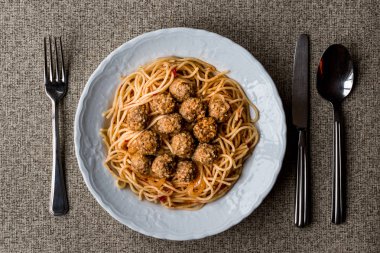 Beyaz tabak spagetti bolognese köfteyle.