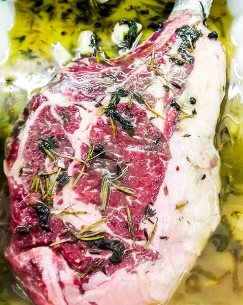 Juicy Raw Veal Chop with greens and olive oil at butcher. — Stock Photo, Image