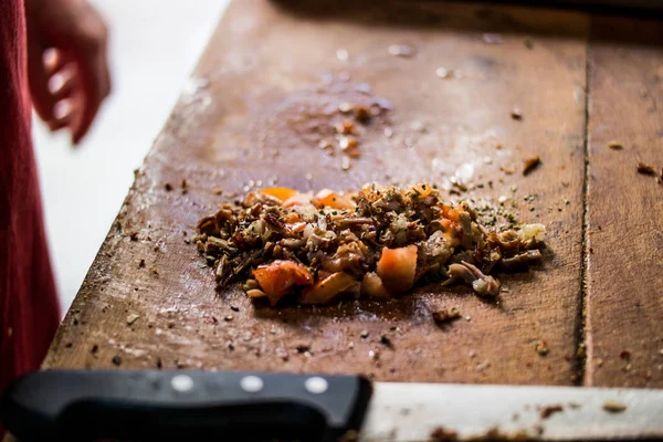 Türkisches Streetfood kokorec wird mit Gewürzen und Tomaten auf hölzerner Oberfläche zubereitet — Stockfoto