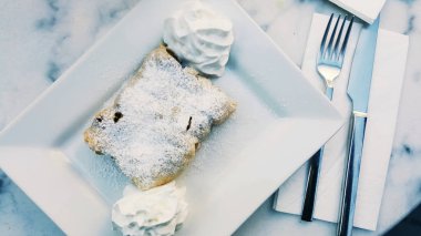 Strudel toz şeker ve krema mermer yüzeyi ile.
