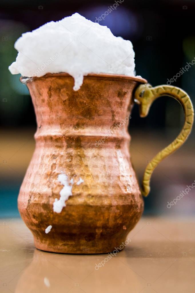 Bebida turca Ayran o Buttermilk con espuma en taza de cobre. 2022