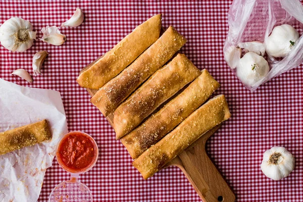 Garlic bread sticks with tomato sauce and parmesan cheese.