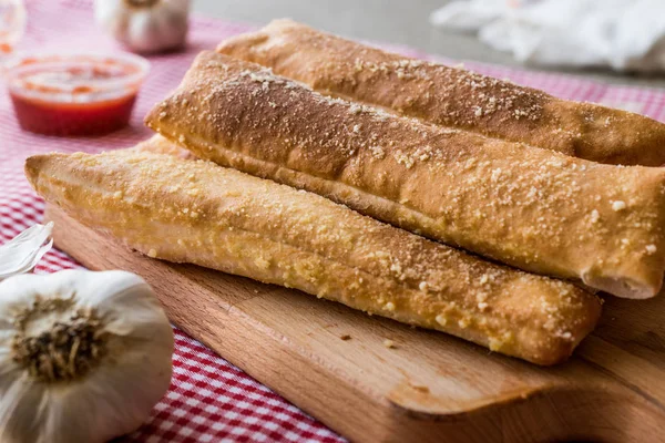 Garlic bread sticks with tomato sauce and parmesan cheese.