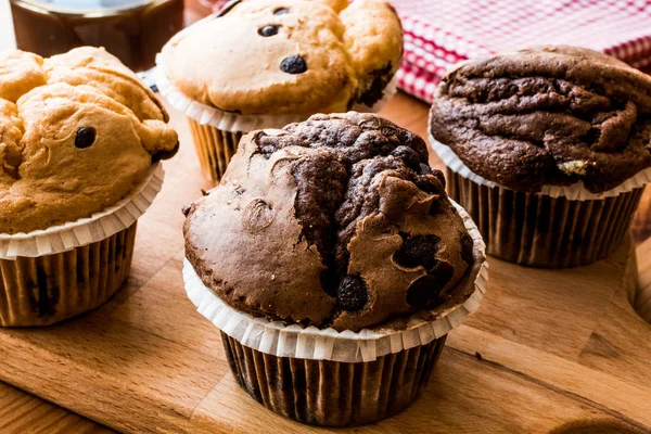 Chocolade en vanille Muffins met koffie op houten oppervlak. — Stockfoto