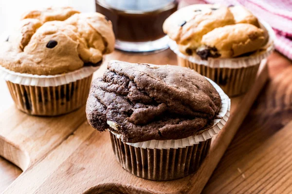 Chocolate and Vanilla Muffins with coffee on wooden surface. — Stock Photo, Image