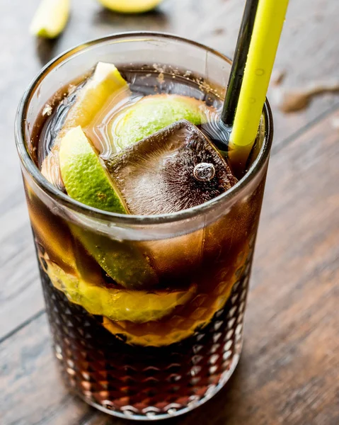 Cuba libre cocktail met limoen en ijs. — Stockfoto