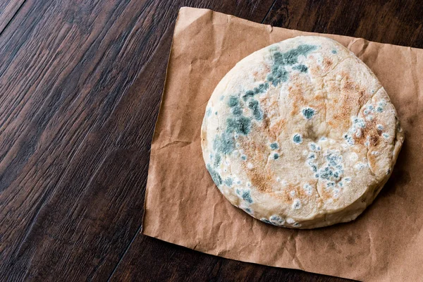 Beschimmeld brood op houten oppervlak. — Stockfoto