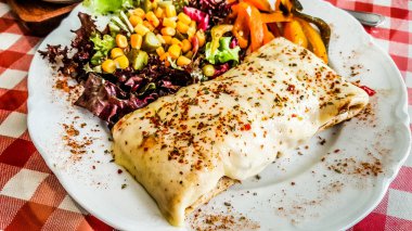 Peynirli krep baharat ve restoran salata ile servis.