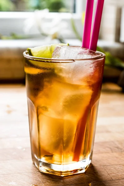 Long Island Eistee Cocktail mit Limette, Eis und rosa Stroh serviert — Stockfoto