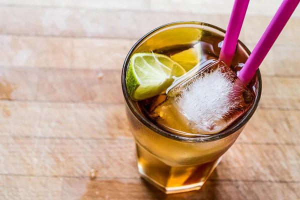Cocktail de thé glacé Long Island avec citron vert, glace et servi avec de la paille rose — Photo