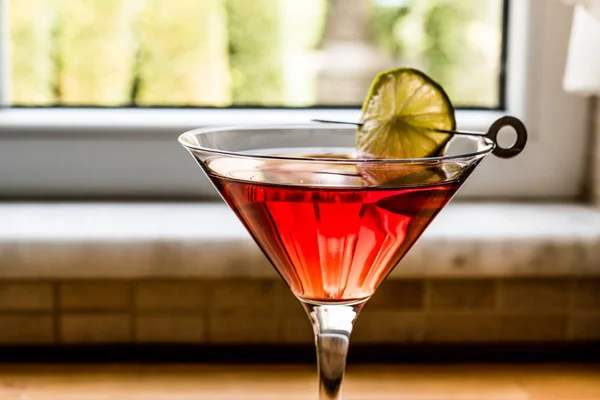 Kosmopolitische Cocktail met kalk op houten oppervlak. — Stockfoto
