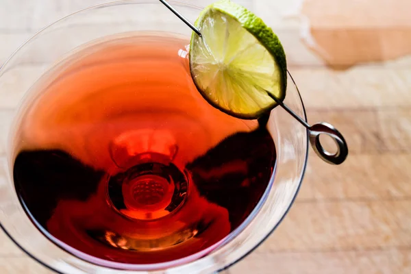 stock image Cosmopolitan Cocktail with lime on wooden surface.