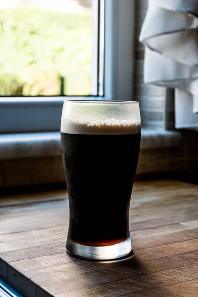 Birra scura a cucina su superficie di legno . — Foto Stock
