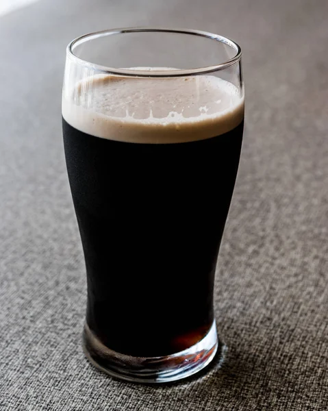Cerveja escura na superfície cinzenta. espaço de cópia . — Fotografia de Stock