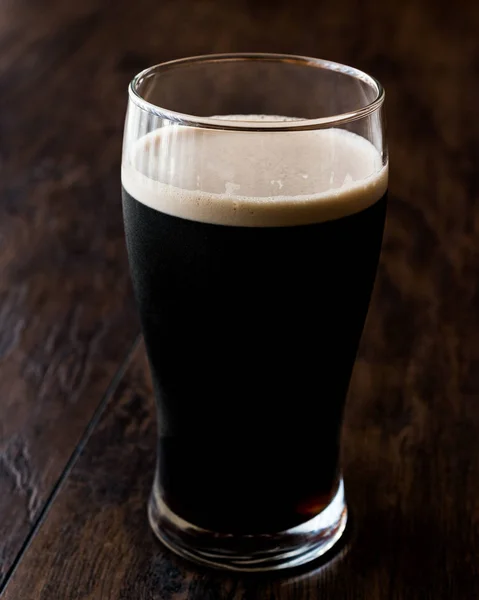 Birra scura su superficie di legno. Vista da vicino . — Foto Stock