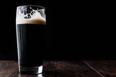 Ahşap yüzey üzerinde karanlık bira. kopya alanı.