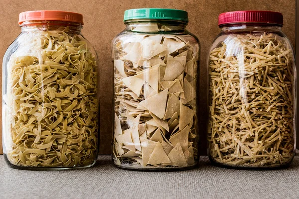 Сырые спагетти с равиоли и лапшой в стеклянной бутылке . — стоковое фото