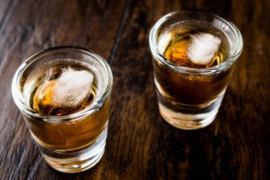 Koyu ahşap yüzeyi buzlu viski çekim.