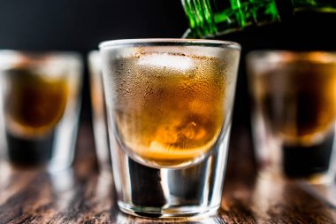 Koyu ahşap yüzeyi buzlu viski çekim dökme.