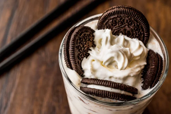 Vanille-Milchshake mit Schokokeksen und schwarzem Stroh. — Stockfoto