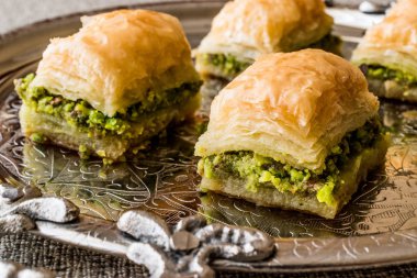 Türk tatlı Baklava gümüş tepsi üzerinde fıstıklı.