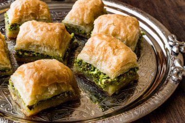 Türk tatlı Baklava gümüş tepsi üzerinde fıstıklı.