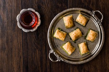 Gümüş tepsi üzerinde çay ile Türk tatlı Baklava.