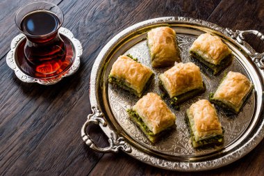 Gümüş tepsi üzerinde çay ile Türk tatlı Baklava.