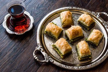 Gümüş tepsi üzerinde çay ile Türk tatlı Baklava.