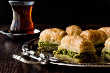 Gümüş tepsi üzerinde çay ile Türk tatlı Baklava.