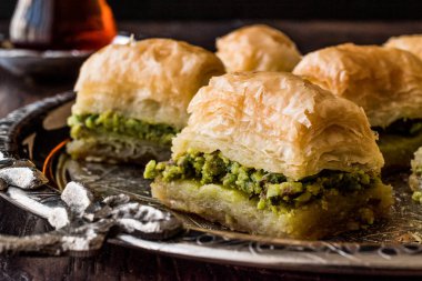 Gümüş tepsi üzerinde çay ile Türk tatlı Baklava.