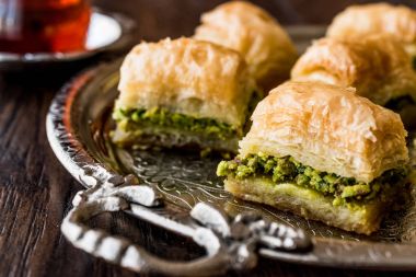 Gümüş tepsi üzerinde çay ile Türk tatlı Baklava.
